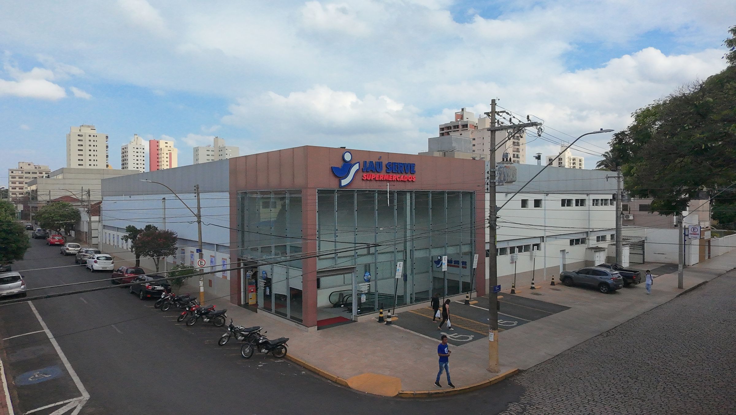 Fachada de supermercado em esquina da cidade vista do alto